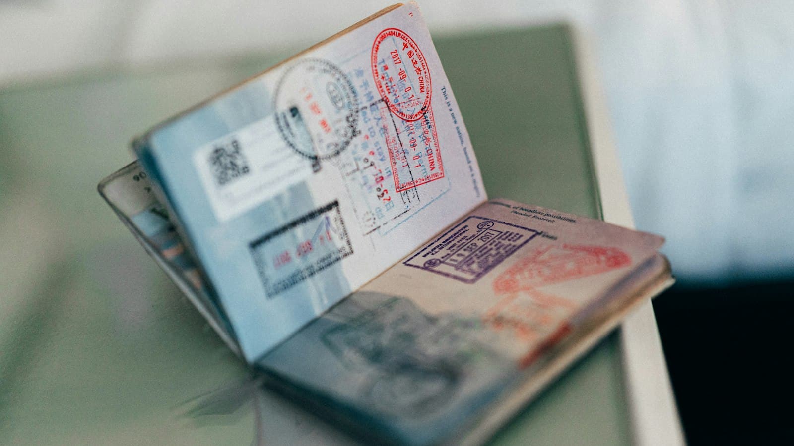 An open passport with colourful visa and entry stamps